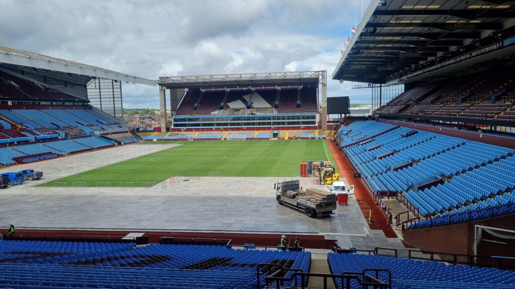 Villa Park von der Tribüne aus: doppellagiges ArmorDeck 3 vor der Nordtribüne, Lkw und Stapler auf dem Bodenschutz, Rasen unbeschädigt